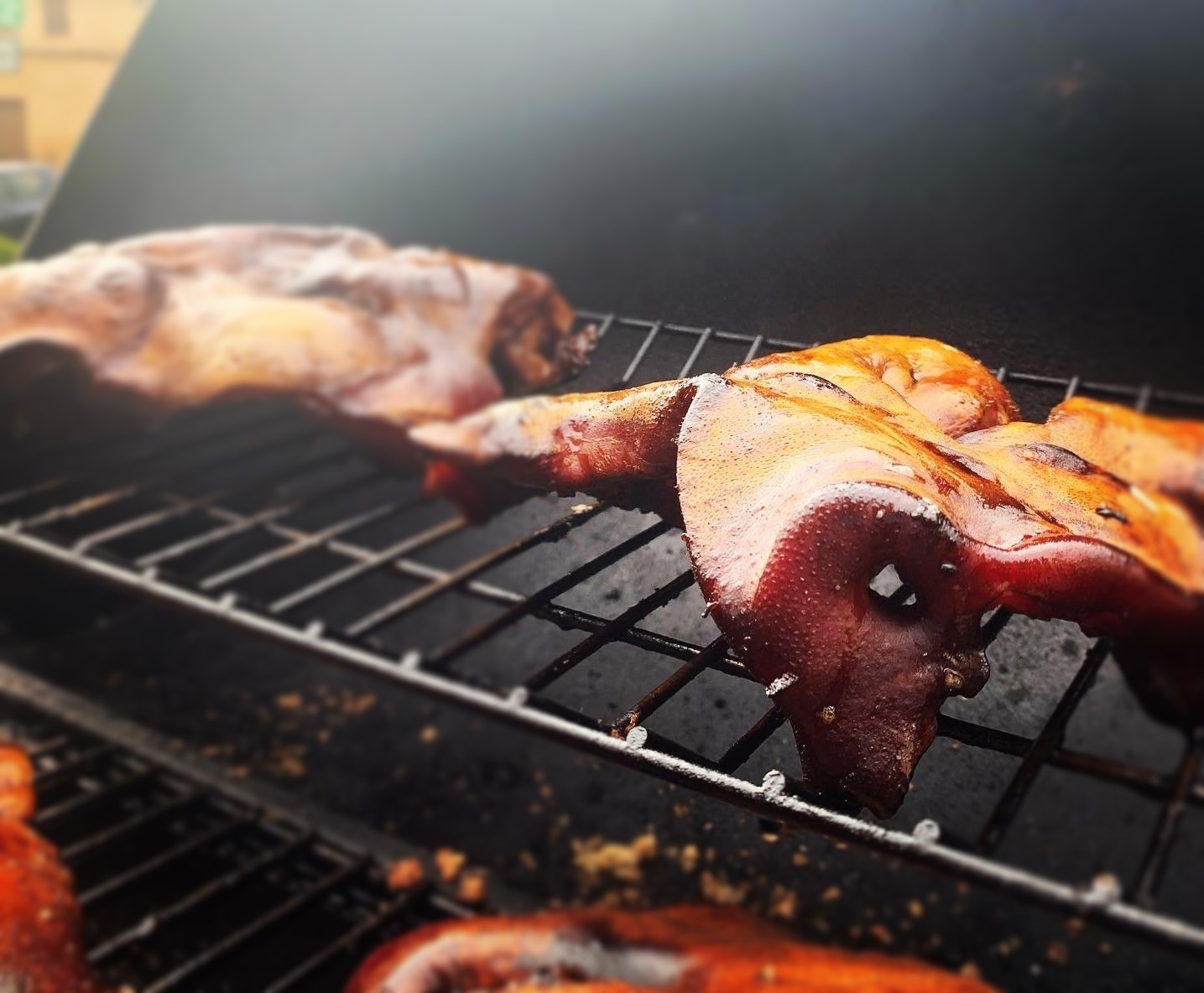 Careta de cerdo dorada sobre la rejilla de la parrilla
